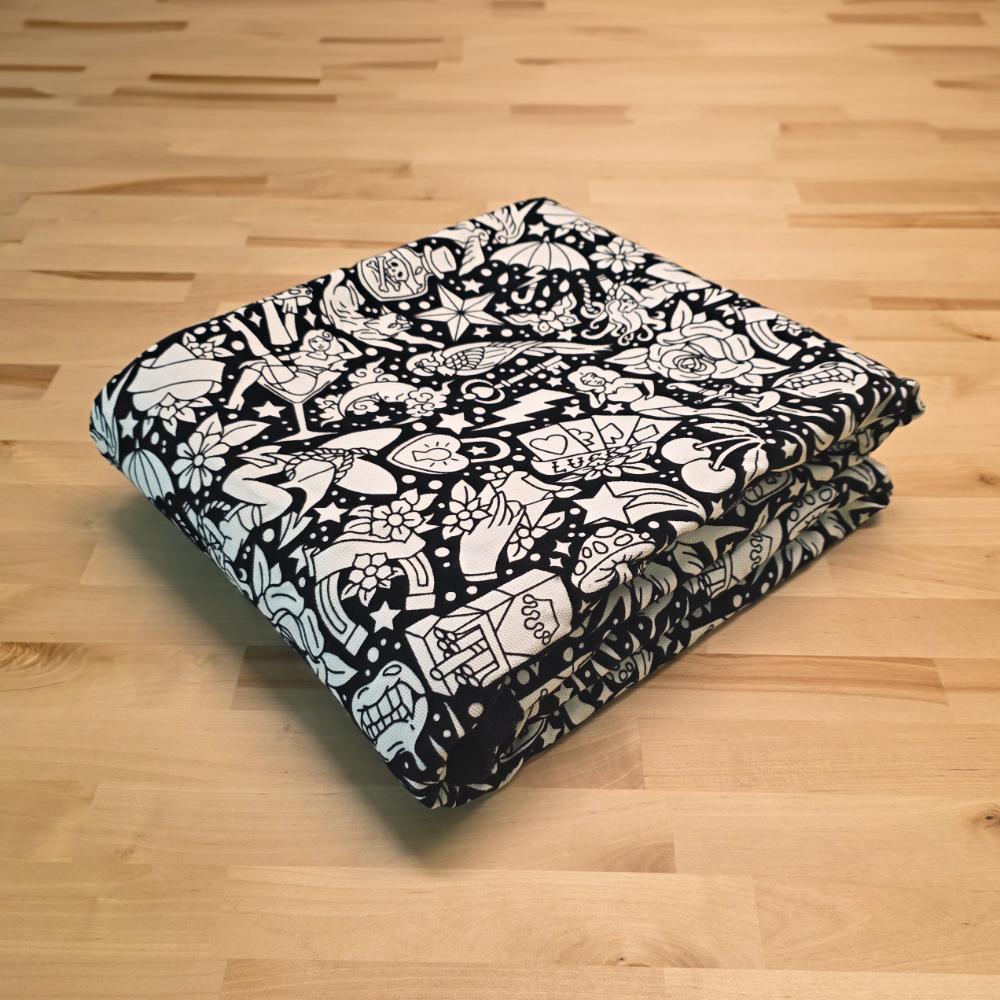 Uncolored classic tattoo styles and patterns blanket folded on a table