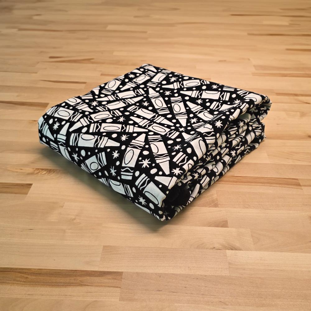 Uncolored many crayon patterned blanket folded on a table