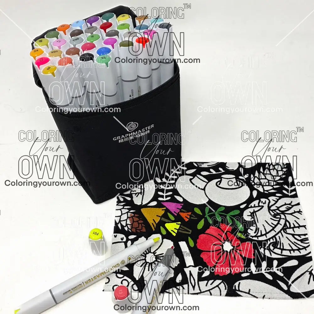 Set of colorful markers with a black carrying case and a piece of coloring fabric featuring mushrooms and foliage on a white background