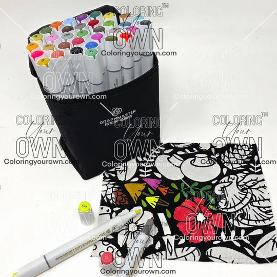 Set of colorful markers with a black carrying case and a piece of coloring fabric featuring mushrooms and foliage on a white background