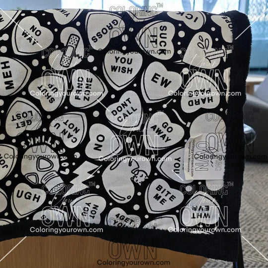 Color Your Own Blanket Anti-Valentines day blanket draped over a couch, not colored, close up