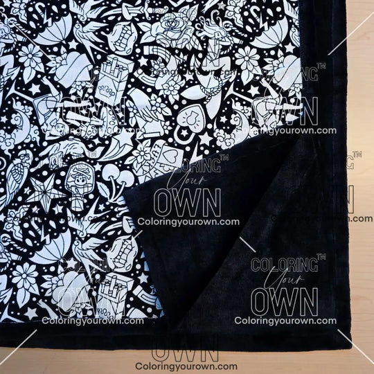 Black and white uncolored classic tattoo styles and patterns blanket with close up view showing black fleece lined underside
