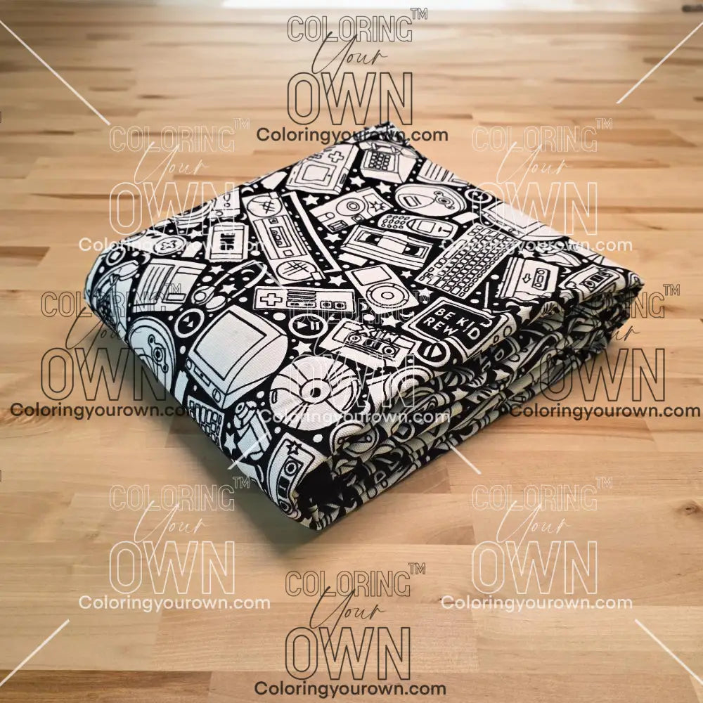 Uncolored retro technology, keyboard ,camera and stereo patterned blanket folded on a table