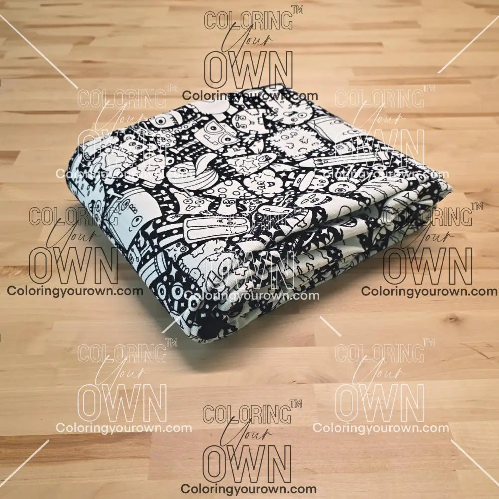 Uncolored  silly monster party patterned blanket folded on a table