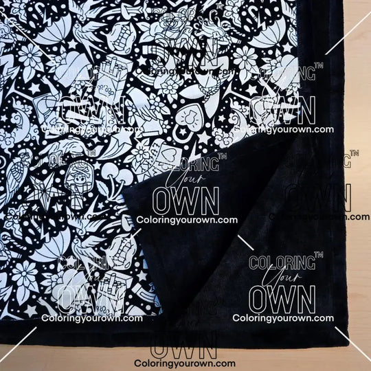 Black and white uncolored classic tattoo styles and patterns blanket with close up view showing black fleece lined underside