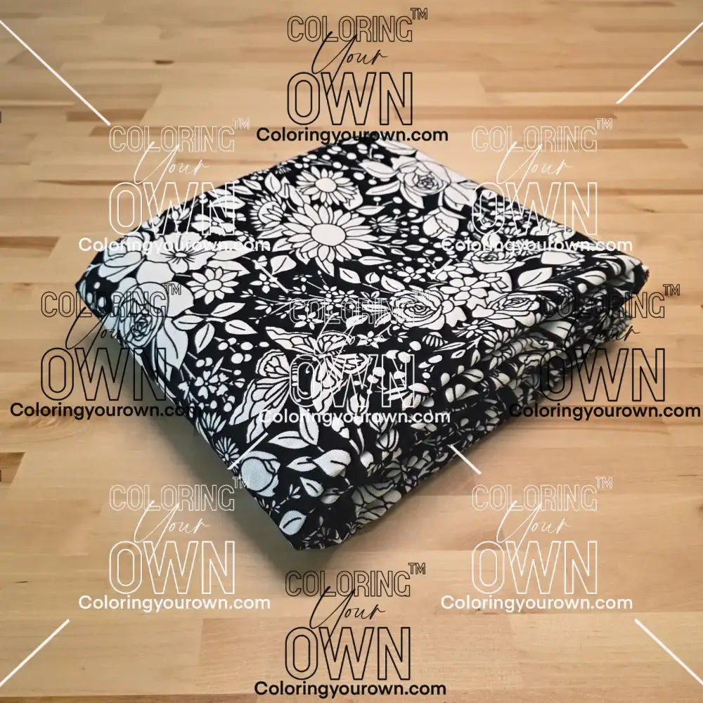 Uncolored vintage floral and butterfly patterned blanket folded on a table