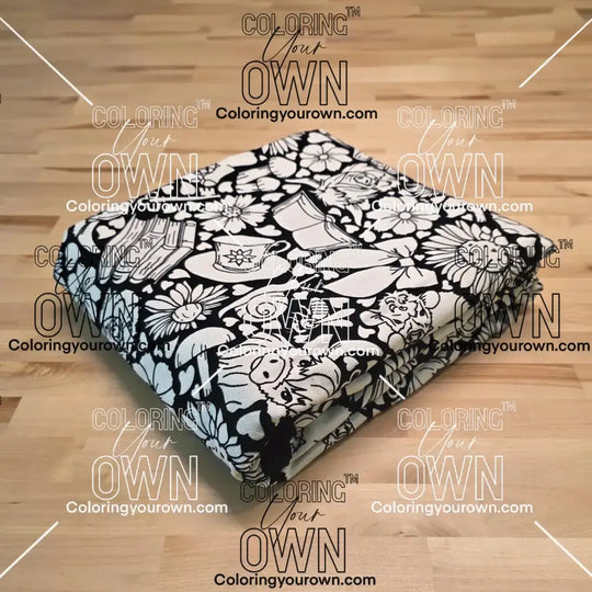 Uncolored highland cow with books and tea patterned blanket folded on a table