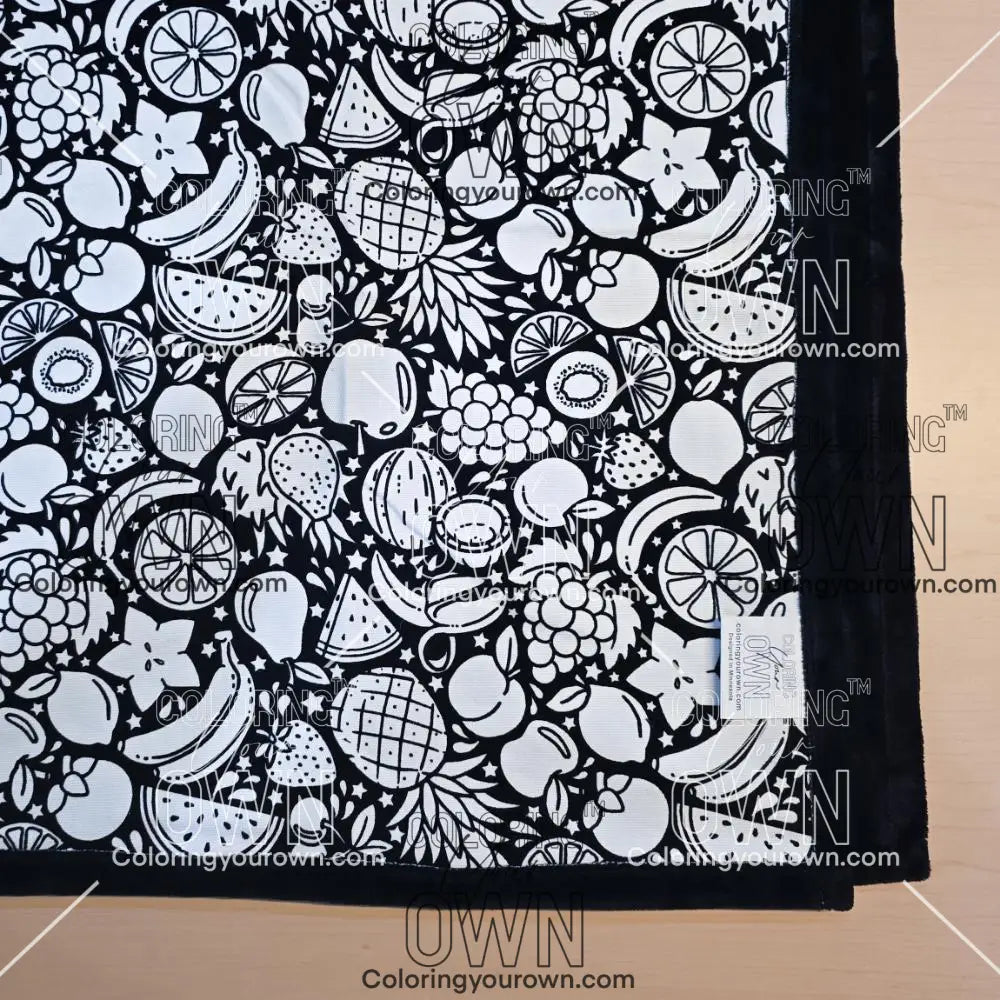 Black and white uncolored fruit variety with pineapples, bananas, watermelons and more patterned blanket with black fleece lined underside close up view