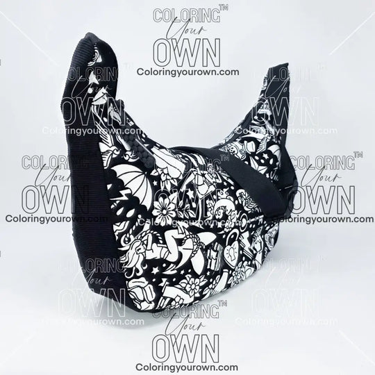 three quarter view of the tattoo coloring crossbody bag which features a black strap, black corduroy base, and a buckle quick release.