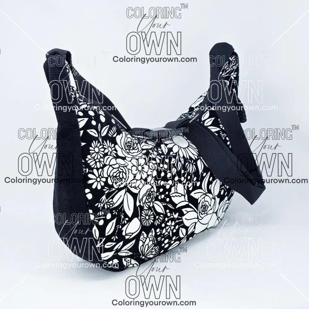 quarter view of the vintage floral coloring crossbody bag partially colored. Black corduroy base with a black strap and quick release buckle. 