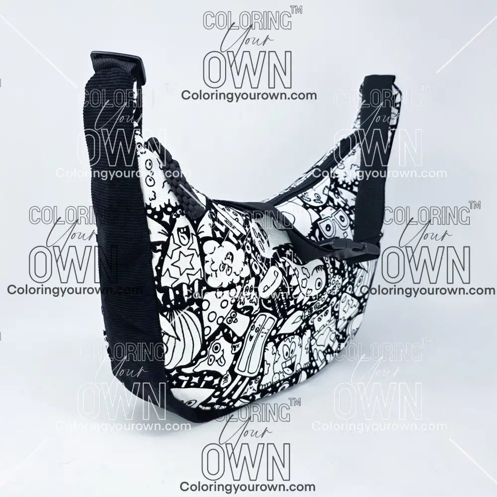 three quarter view of the silly monsters coloring crossbody bag which features a black strap, black corduroy base, and a buckle quick release.