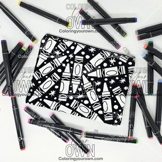 Photo of a black and white flat makeup bag with lots of colorful markers beside it indicating the customer gets to color it when they receive theirs. This is the same bag as the pencil case - Side A