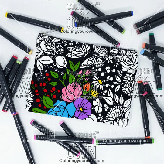 Photo of a black and white flat pencil pouch with lots of colorful markers beside it indicating the customer gets to color it when they receive theirs. This is the same bag as the pencil case - this one is partially colored - this bag has images of vintage flowers on it