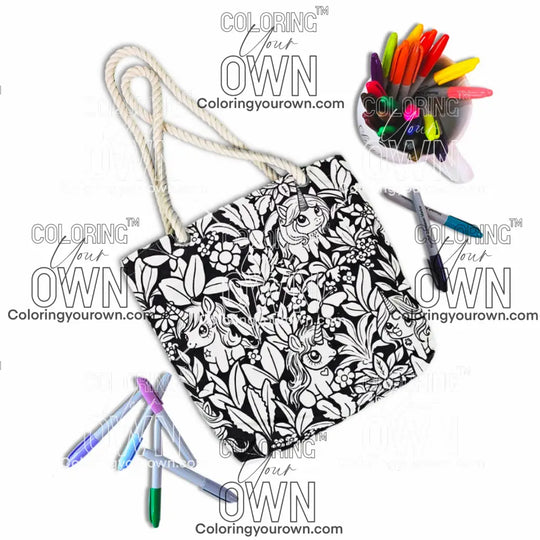 photo of an uncolored unicorn color your own tote on a white background sitting next to a cup full of markers.