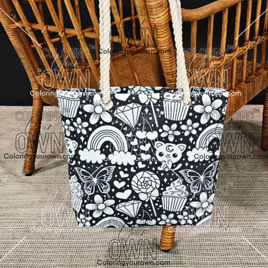 photo of an uncolored happy doodle color your own tote bag hanging on the back of a wicker chair.