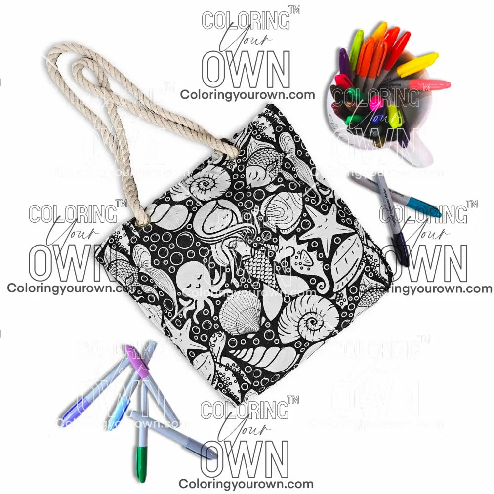 photo of an uncolored color your own tote in mermaid print surrounded by markers