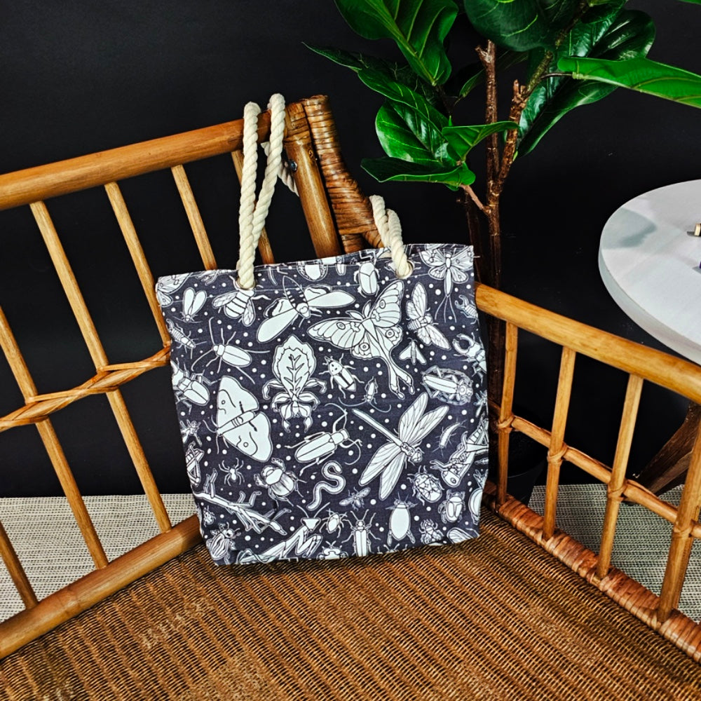 photo of an uncolored color your own bug tote sitting on a wicker chair