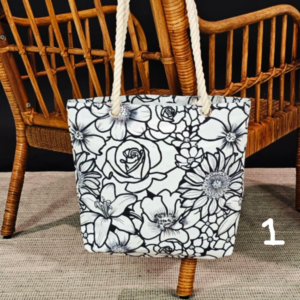 photo of an uncolored floral canvas tote hanging on the back of a wicker chair