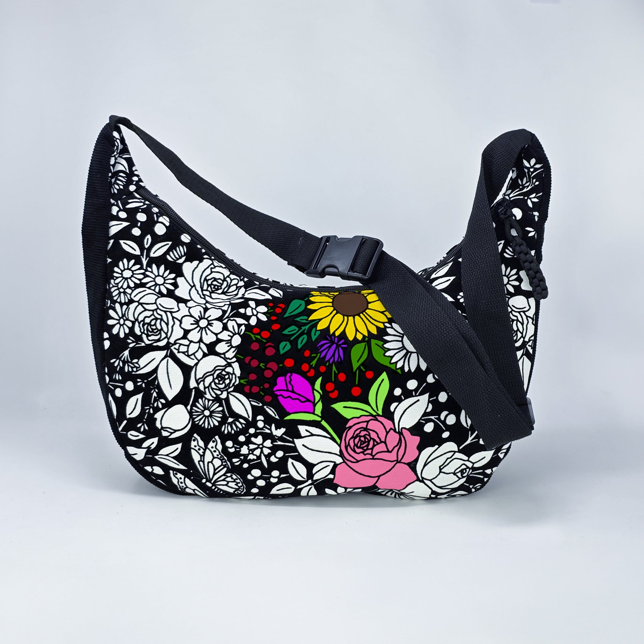 front facing view of the vintage floral coloring crossbody bag partially colored. Black corduroy base with a black strap and quick release buckle. 
