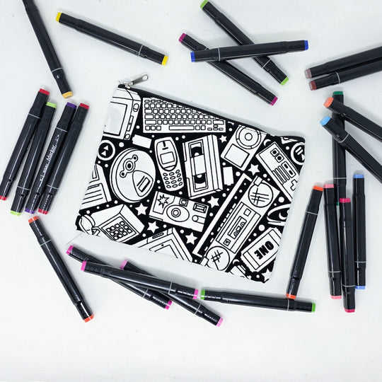 Photo of a black and white flat pencil pouch with lots of colorful markers beside it indicating the customer gets to color it when they receive theirs. This is the same bag as the pencil case and makeup bag - Side B - this bag has images of a disposable camera, boombox, ipod, cd player, keyboard, floppy disk, nokia phone, and more