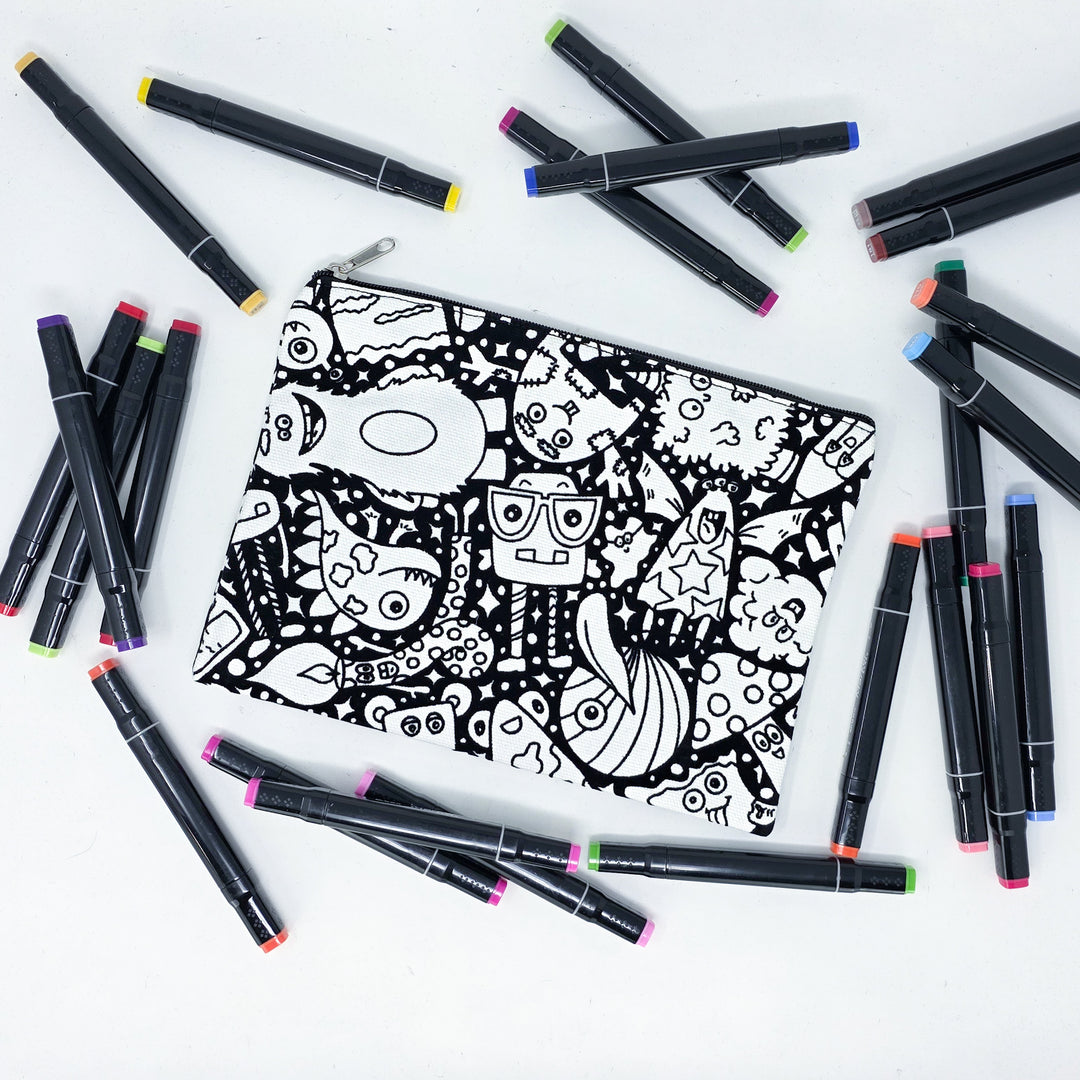 Photo of a black and white flat pencil pouch with lots of colorful markers beside it indicating the customer gets to color it when they receive theirs. This is the same bag as the pencil case and makeup bag - Side B - this bag has images of silly monsters all over